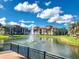 Scenic view of a pond with fountain with community buildings and lush landscaping at 8351 38Th Street E Cir # 302, Sarasota, FL 34243