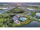 Aerial view of a Primary-planned community, showcasing the clubhouse, pool, playground, lakes, and surrounding homes at 11021 Moonsail Dr, Parrish, FL 34219