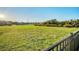 Expansive backyard with a lush green lawn, a pond, and distant views of neighboring homes at 11021 Moonsail Dr, Parrish, FL 34219