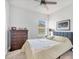Clean bedroom featuring dark wood dresser, ceiling fan, and ample natural light at 11021 Moonsail Dr, Parrish, FL 34219