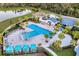 Aerial shot of a community pool with cabanas, lounge chairs, and palm trees at 11021 Moonsail Dr, Parrish, FL 34219