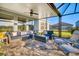 Relaxing covered patio with comfortable blue lounge seating and screened enclosure at 11021 Moonsail Dr, Parrish, FL 34219