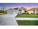 Charming single-story home with a manicured lawn, colorful sunset, and a two-car garage at 11021 Moonsail Dr, Parrish, FL 34219