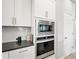Modern kitchen boasts stainless steel microwave and oven appliances, plus white cabinets at 11021 Moonsail Dr, Parrish, FL 34219