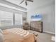 Bright main bedroom with neutral color scheme, tray ceiling and a large flat screen TV at 11021 Moonsail Dr, Parrish, FL 34219