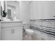 Clean bathroom with a stylish vanity, toilet, and shower featuring a striped shower curtain at 11522 Trivio Ter, Palmetto, FL 34221