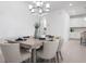 A dining area with a modern table setting, comfortable chairs, and elegant chandelier at 11522 Trivio Ter, Palmetto, FL 34221