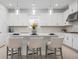 Bright kitchen features white cabinets, stone countertops, backsplash, and pendant lighting over the island with seating at 11522 Trivio Ter, Palmetto, FL 34221