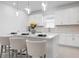 Bright kitchen features white cabinets, stone countertops, backsplash, pendant lighting, and seating at island at 11522 Trivio Ter, Palmetto, FL 34221