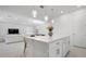 Open concept kitchen featuring a central island, white cabinets and appliances and access to the dining and living areas at 11522 Trivio Ter, Palmetto, FL 34221