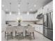 Modern kitchen with stainless steel appliances, white cabinets, and stylish pendant lighting at 11522 Trivio Ter, Palmetto, FL 34221