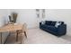 Bright home office featuring a wooden desk, blue sofa, and geometric area rug at 11522 Trivio Ter, Palmetto, FL 34221