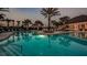 A community pool surrounded by chaise lounges, palm trees, and tropical foliage, offering a relaxing escape at 11522 Trivio Ter, Palmetto, FL 34221