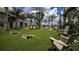 Outdoor recreation area on a green lawn with seating, lush palms, and cornhole boards for neighborhood fun at 11522 Trivio Ter, Palmetto, FL 34221