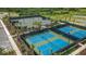 Aerial view of tennis courts surrounded by lush greenery and palm trees, providing a scenic setting for recreation at 11522 Trivio Ter, Palmetto, FL 34221