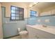 Quaint bathroom with light blue tiled walls, a white sink, toilet, and a framed mirror at 124 E 119Th Ave, Tampa, FL 33612