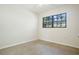 A simple bedroom with carpet, a window with a view of the trees, and neutral-toned walls at 124 E 119Th Ave, Tampa, FL 33612