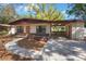 Inviting home featuring a covered carport, brick accents, and landscaped pathway to the front door at 124 E 119Th Ave, Tampa, FL 33612