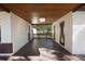 A covered outdoor patio with a wooden ceiling and view of the backyard with a white fence at 124 E 119Th Ave, Tampa, FL 33612