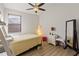Cozy bedroom featuring a twin bed, modern ceiling fan, wood flooring, and a full length mirror at 12420 Aster Ave, Bradenton, FL 34212
