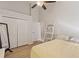 Bright bedroom with wood floors, closet, ceiling fan, ladder shelving, and a large mirror at 12420 Aster Ave, Bradenton, FL 34212