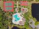 Breathtaking aerial view of resort-style pool, tennis courts, playground, and surrounding scenery at 12420 Aster Ave, Bradenton, FL 34212