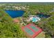Aerial shot highlighting tennis courts, a basketball court, pool, playground, lakes, and surrounding foliage at 12420 Aster Ave, Bradenton, FL 34212