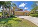 Stunning two-story home with a well-manicured lawn, tall palm trees and a large driveway leading to a spacious garage at 12420 Aster Ave, Bradenton, FL 34212