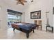 Spacious game room featuring a pool table, and a view to the pool, ideal for entertainment and Gathering fun at 12420 Aster Ave, Bradenton, FL 34212