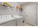 Practical laundry room featuring a washer, a dryer, and a shelf for storage, designed for efficient laundry tasks at 12420 Aster Ave, Bradenton, FL 34212