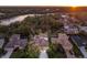 Sunset aerial of a neighborhood, highlighting mature trees, multiple lakes, and tile roofs at 13414 Goldfinch Dr, Lakewood Ranch, FL 34202