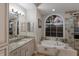 Bright bathroom with a soaking tub, granite countertops, and a decorative framed mirror at 13414 Goldfinch Dr, Lakewood Ranch, FL 34202