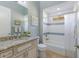 Well-lit bathroom features granite counters, custom cabinets and a white tiled shower and tub at 13414 Goldfinch Dr, Lakewood Ranch, FL 34202