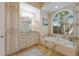 Elegant bathroom featuring a large bathtub beneath an arch window at 13414 Goldfinch Dr, Lakewood Ranch, FL 34202