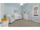 Light and airy Bedroom featuring a crib, comfortable chair, and soft blue walls at 13414 Goldfinch Dr, Lakewood Ranch, FL 34202