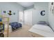 Bright, carpeted bedroom featuring twin beds, closet and decorated with planet themed décor at 13414 Goldfinch Dr, Lakewood Ranch, FL 34202