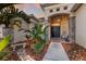 Inviting front entrance features stone accents, lush landscaping, a covered porch, and a welcoming black door at 13414 Goldfinch Dr, Lakewood Ranch, FL 34202