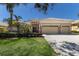 Charming home exterior with tile roof, 3-car garage, stone accents, and tropical landscaping at 13414 Goldfinch Dr, Lakewood Ranch, FL 34202