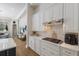 Kitchen with white cabinets, stone backsplash, and stainless steel hood at 13414 Goldfinch Dr, Lakewood Ranch, FL 34202