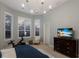 Comfortable bedroom with a large bed, dresser, and exercise bike by the window at 13414 Goldfinch Dr, Lakewood Ranch, FL 34202