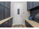 Mudroom with blue cabinets and door, bench, and wood countertop at 13414 Goldfinch Dr, Lakewood Ranch, FL 34202