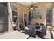 Covered outdoor patio boasts a grill, dining table, ceiling fan, and view of the surrounding landscape at 13414 Goldfinch Dr, Lakewood Ranch, FL 34202