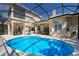 Outdoor pool area featuring a screened-in pool, patio seating, and manicured lawn at 13414 Goldfinch Dr, Lakewood Ranch, FL 34202