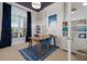 Stylish home office with navy accents, built-in shelving, and abundant natural light at 13414 Goldfinch Dr, Lakewood Ranch, FL 34202
