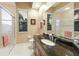 Bathroom with a large dark granite countertop, glass shower, and tile flooring at 13635 Legends Walk Ter, Lakewood Ranch, FL 34202