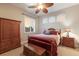 Cozy bedroom with wood furniture features a window with plantation shutters and a ceiling fan at 13635 Legends Walk Ter, Lakewood Ranch, FL 34202