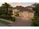Stunning single-Gathering home showcases a three-car garage and a tile roof surrounded by lush landscaping at 13635 Legends Walk Ter, Lakewood Ranch, FL 34202