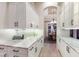 Hallway with marble countertops and white cabinets leading to dining room at 13635 Legends Walk Ter, Lakewood Ranch, FL 34202