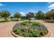 Beautiful landscaping with blooming trees, flowering plants, and a statue on a bricked pathway overlooking the golf course at 13635 Legends Walk Ter, Lakewood Ranch, FL 34202