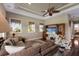Living room with ceiling fan, entertainment center, large brown sectional couch, and a view from the windows at 13635 Legends Walk Ter, Lakewood Ranch, FL 34202